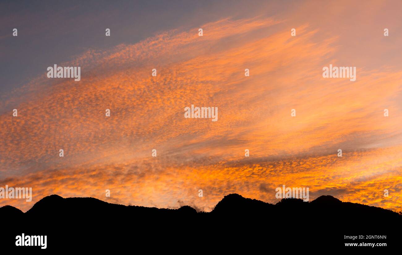 Abendhimmel und silhoutte Berg, bunte und dramatische Sonnenuntergang Himmel mit goldenen Wolken, Natur Hintergrund, Tapete Stockfoto