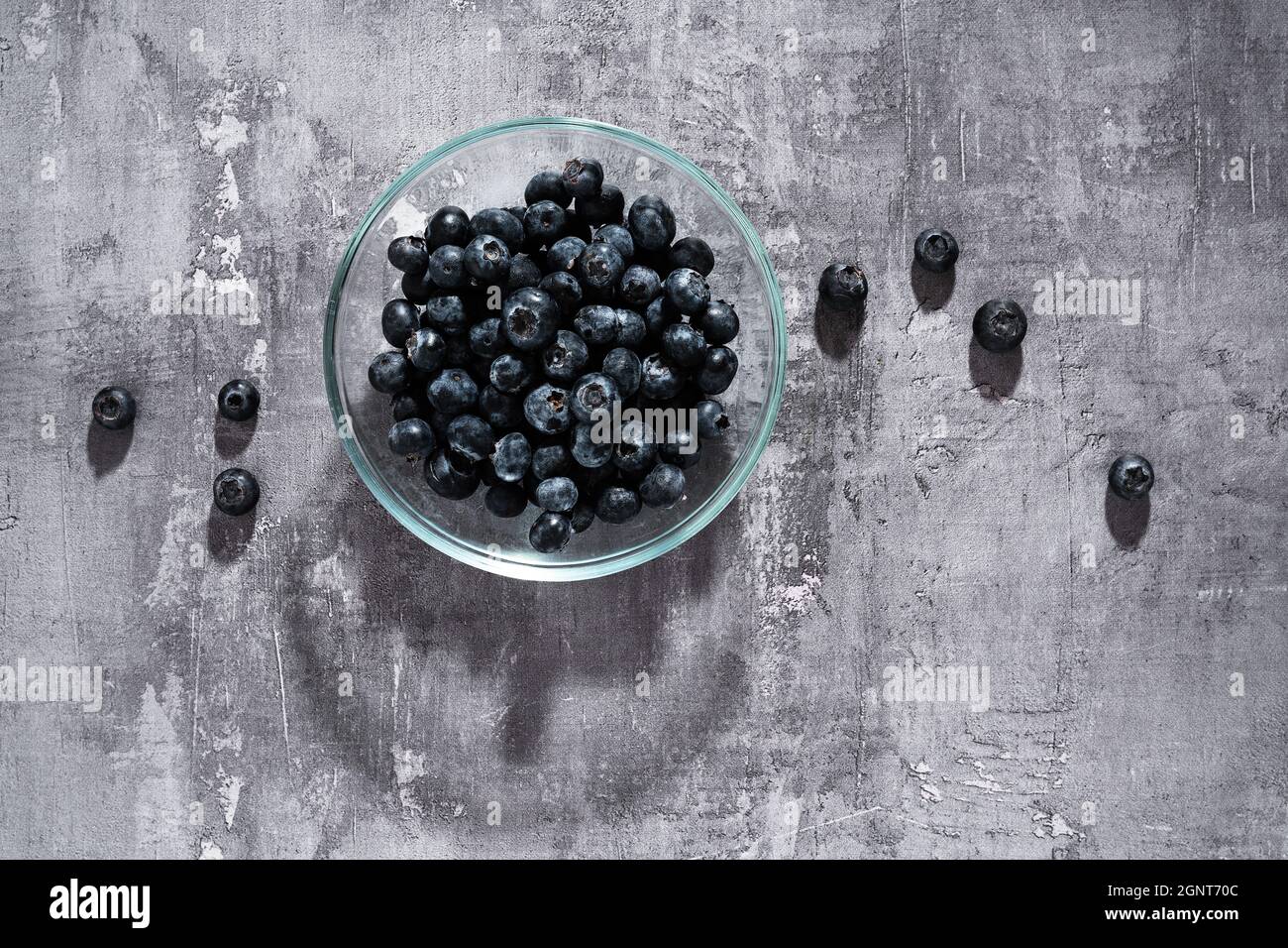 Heidelbeeren in einer Glasplatte auf dunklem Hintergrund Stockfoto
