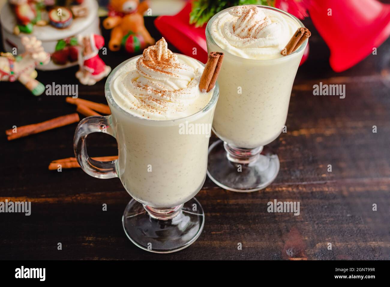 Eierbecher mit Schlagsahne und Zimt mit weihnachtlicher Einstellung: Hausgemachte Eierbecher mit Schlagsahne garniert Stockfoto