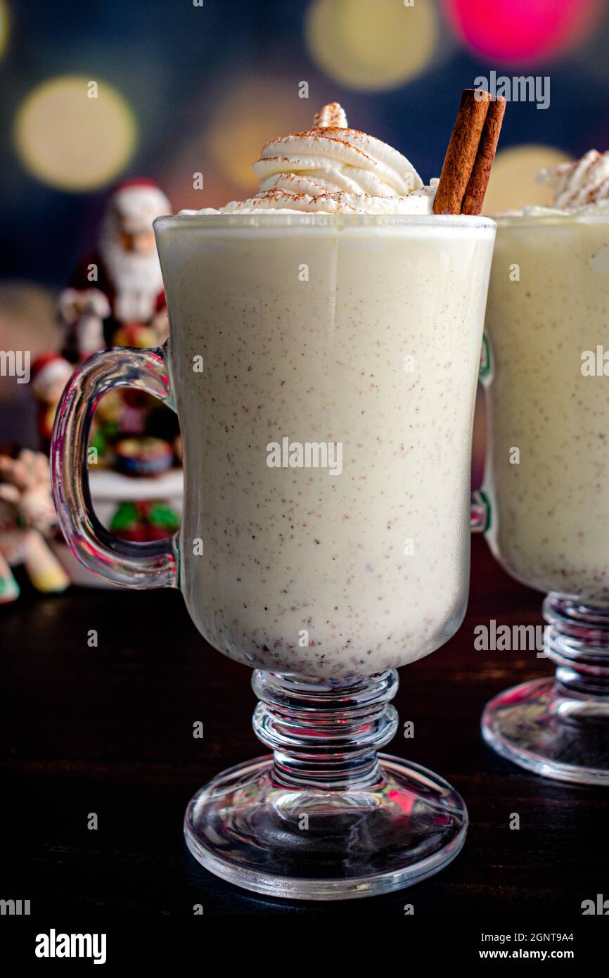 Eierbecher mit Schlagsahne und Zimt mit weihnachtlicher Einstellung: Hausgemachte Eierbecher mit Schlagsahne garniert Stockfoto