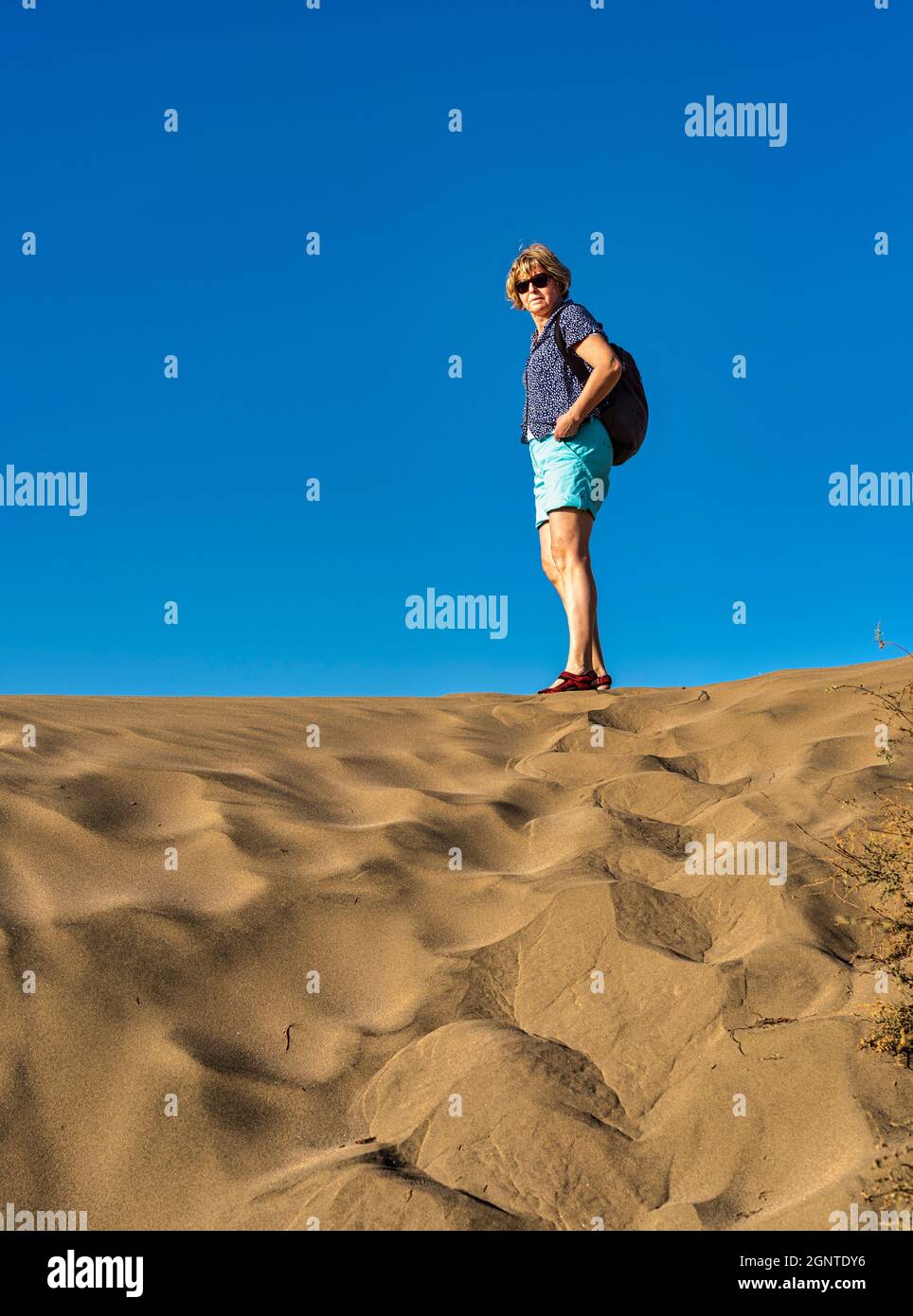 Eine alleinerziehende Frau, die auf den Sanddünen der Kanarischen Inseln steht Stockfoto