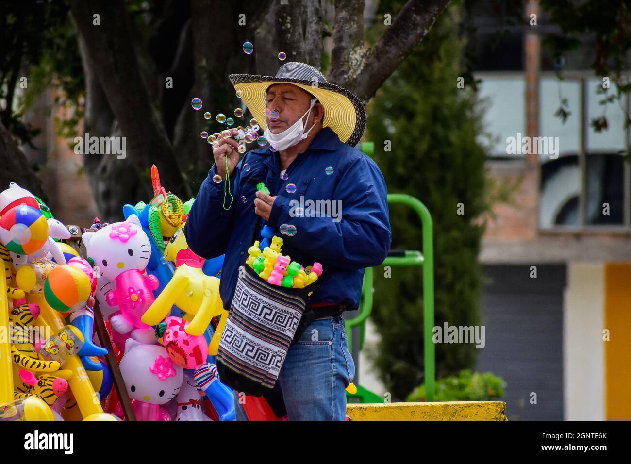 Ein Straßenhändler bläst am 15. August 2021 Blasen aus einem Spielzeug in Cumbal - Nariño, Kolumbien. Stockfoto
