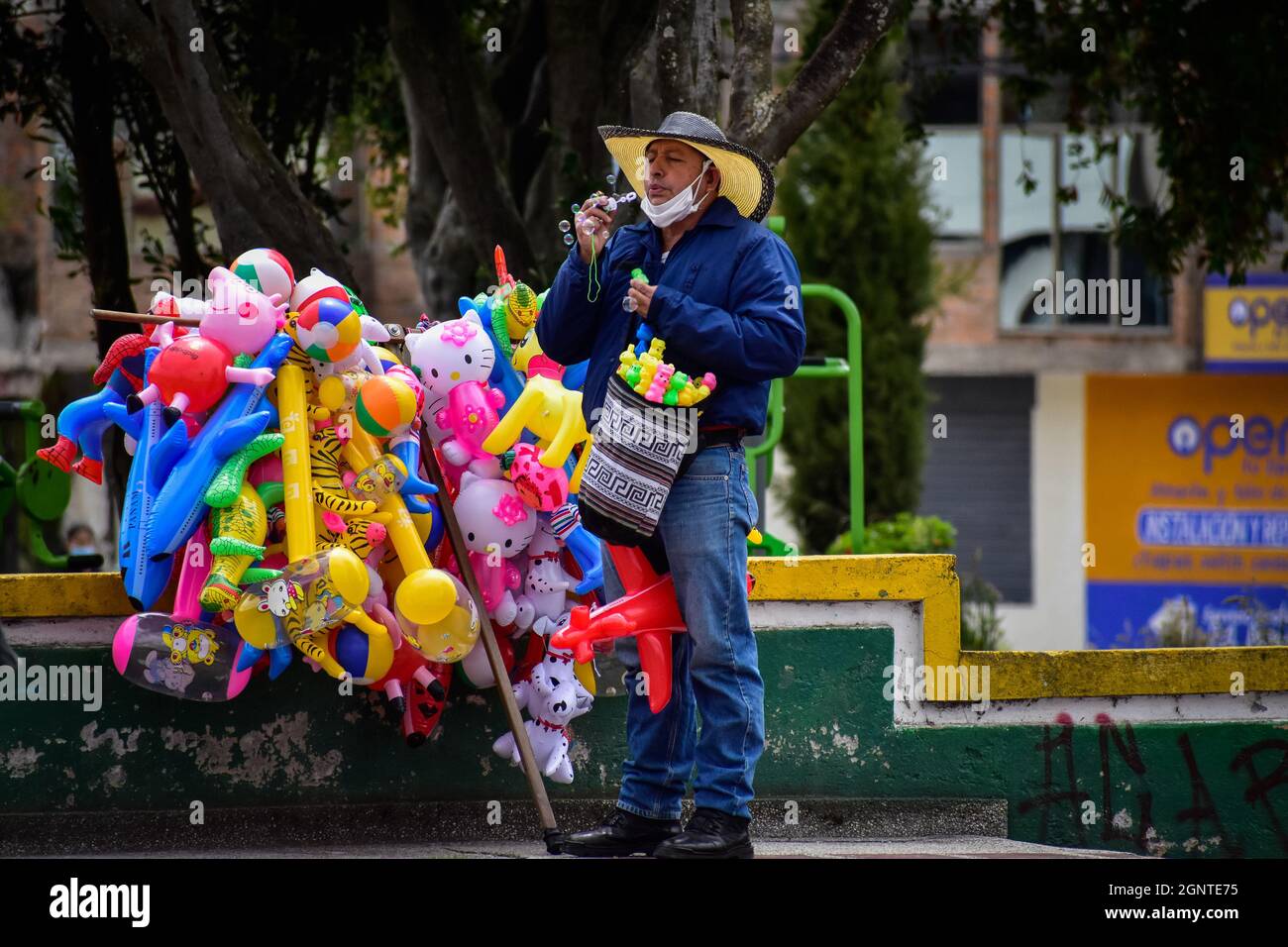 Ein Straßenhändler bläst am 15. August 2021 Blasen aus einem Spielzeug in Cumbal - Nariño, Kolumbien. Stockfoto