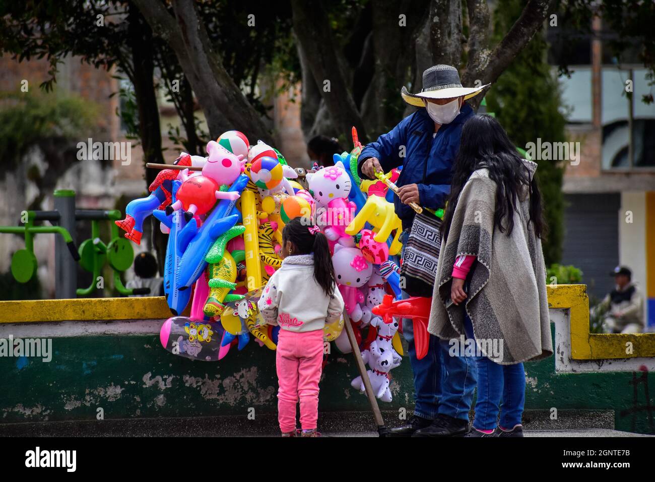 Eine Mutter und ihre Tochter kaufen am 15. August 2021 Gummiballons und Spielzeug bei einem Straßenhändler in Cumbal - Nariño, Kolumbien. Stockfoto