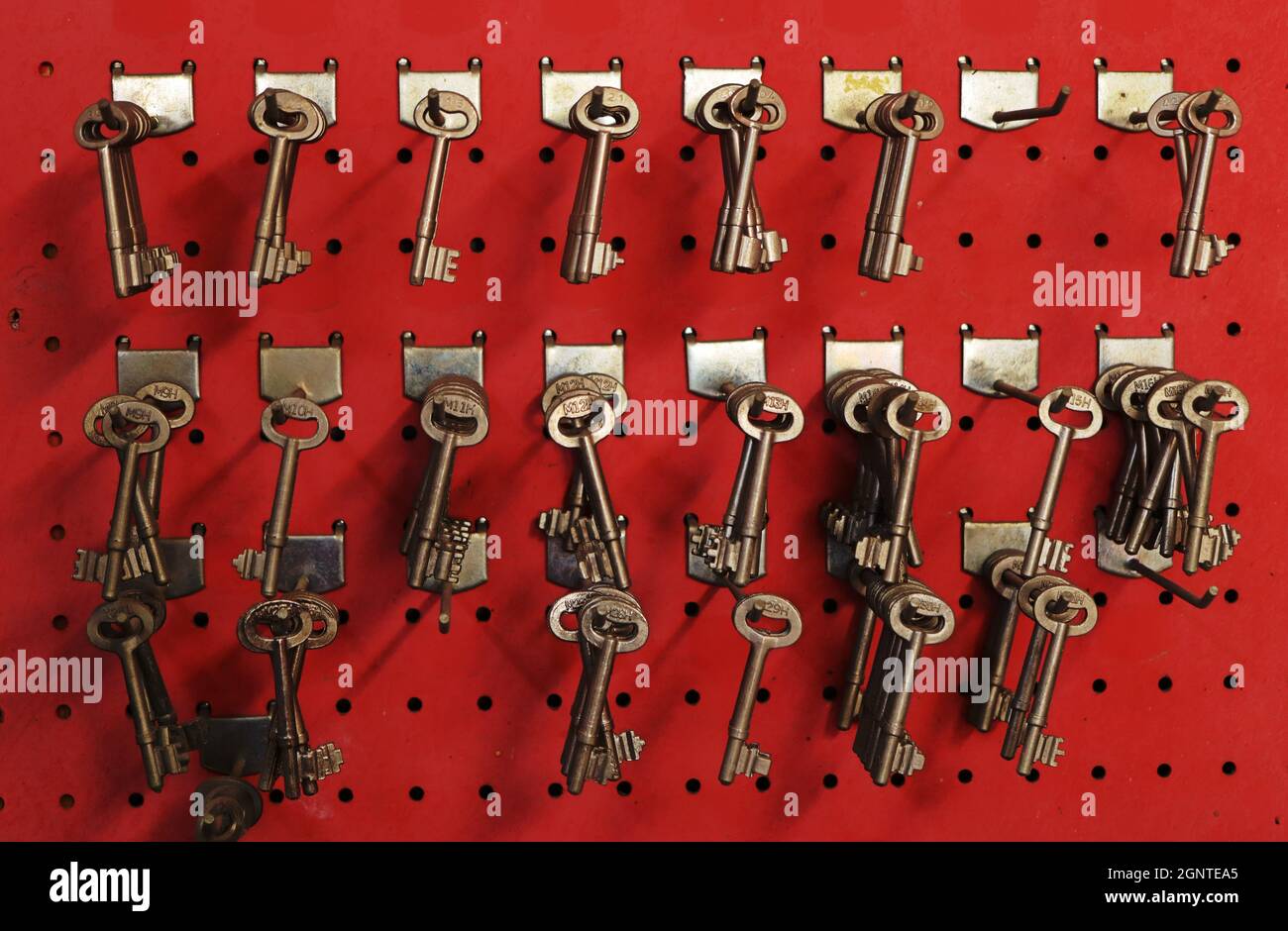 Limassol - Zypern - 20. September 2021: Ungeschnittener Schlüssel in der Schlosserei auf hellrotem Hintergrund Stockfoto