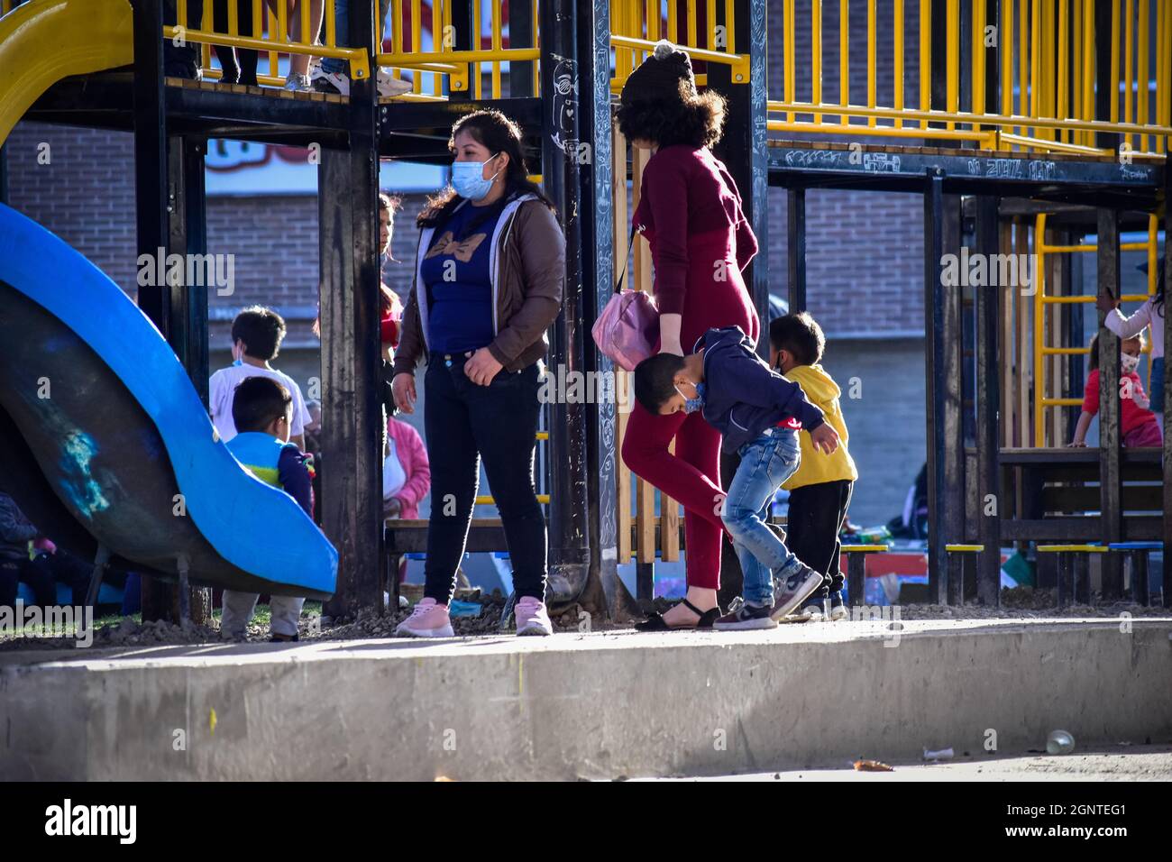Eine Mutter besucht einen Park mit ihren Kindern, die am 8. August 2021 in Cumbal - Nariño, Kolumbien, Gesichtsschutzmasken gegen die COVID-19-Pandemie tragen. Stockfoto