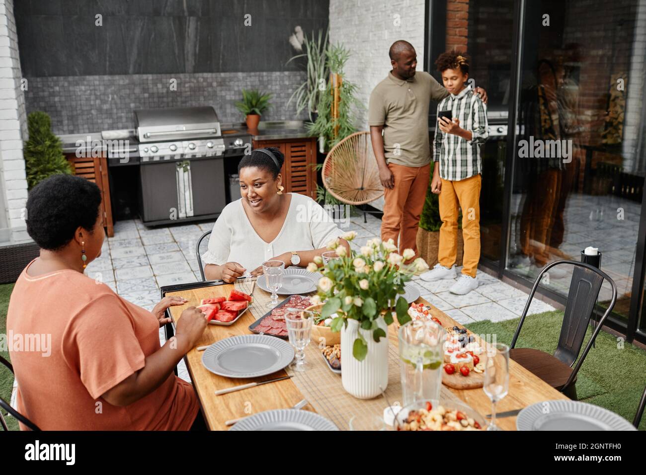 Porträt einer modernen afroamerikanischen Familie, die das Abendessen auf der Terrasse genießt, Kopierfläche Stockfoto