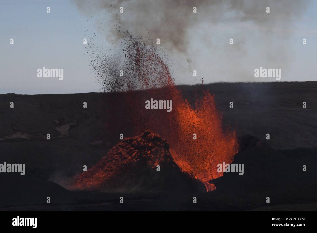 Vulkanischer Schlitz am Fagradalsfjall, Island, der glühende orange-rote Lava ausbricht. Schwarze gekühlte Lava im Vordergrund. Stockfoto