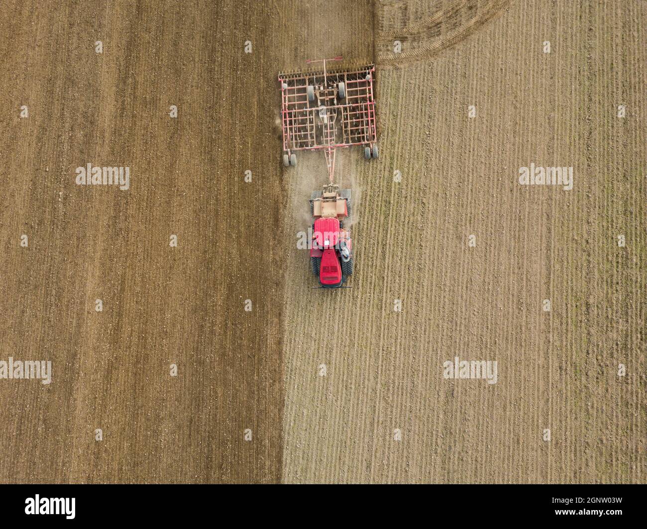 Luftaufnahme eines Traktors, der auf dem Land ein Stoppelfeld pflügt. Landwirtschaftlicher Traktor pflügt Bodenfeld für die Aussaat. Luftaufnahme von oben von der Drohne . Stockfoto