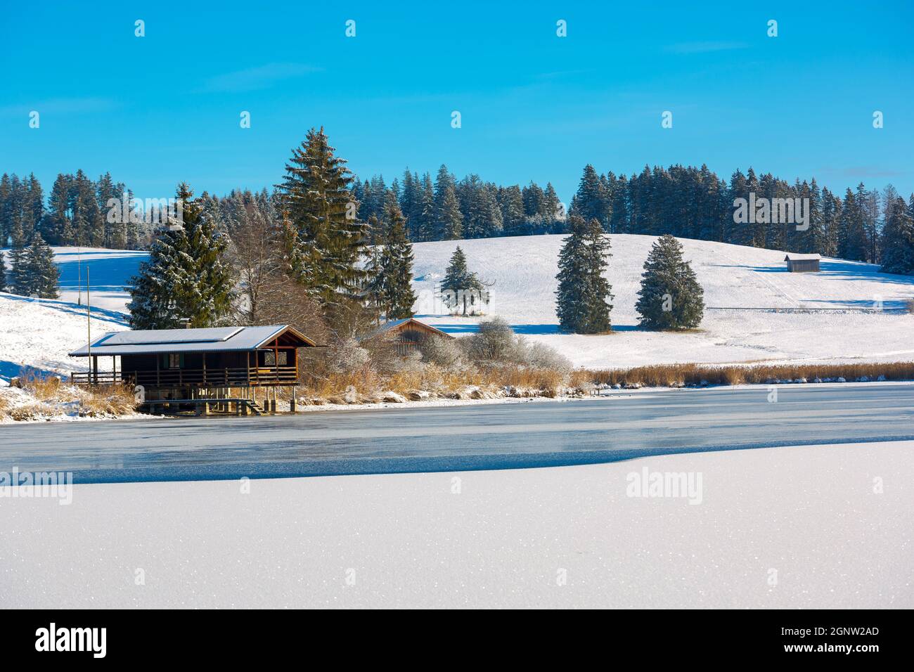 Bayerische Fischerhütte am See im Schnee Stockfoto