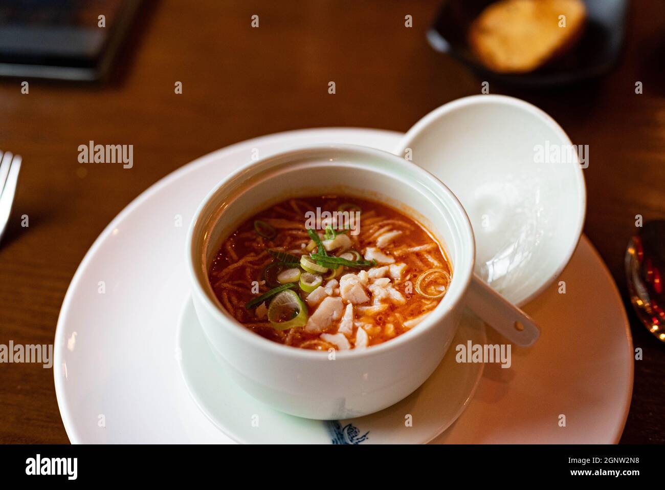 Chinesische Tomatensuppe mit Frühlingszwiebeln in einem Restaurant Stockfoto
