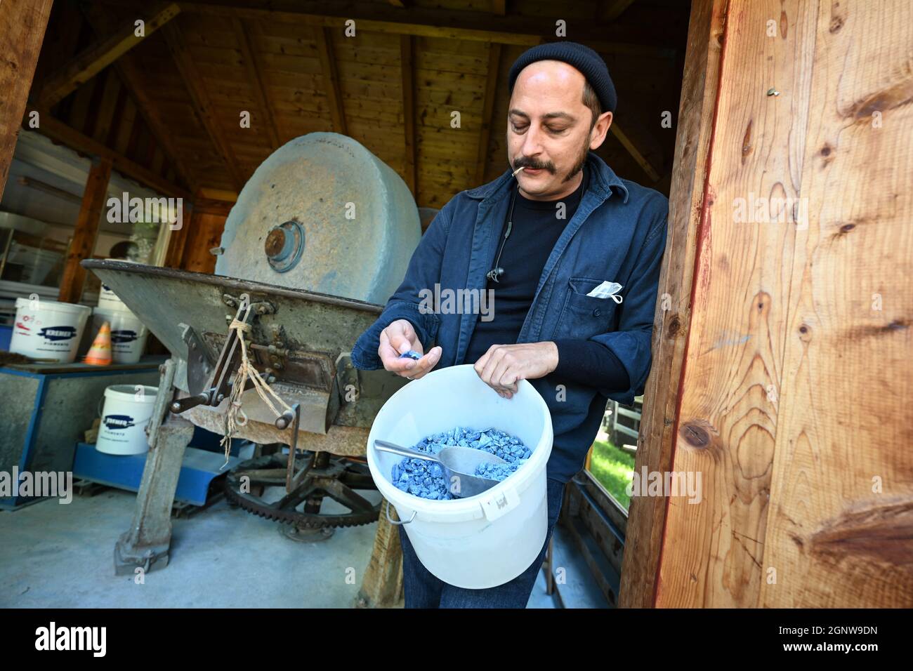 Aichstetten, Deutschland. September 2021. David Kremer, Geschäftsführer von Kremer Pigments, steht vor einer Farbfabrik, in der blaue Azurit-Steine fein gemahlen werden. Mit Mühlsteinen, Öfen und Sieben macht eine alte Getreidemühle die Welt ein wenig bunter: Das Familienunternehmen im Allgäu ist eines der letzten weltweit, das historische Pigmente produziert. (An dpa-KORR 'Wer mahlt zuletzt: Mühle hält historische Farbproduktion am Leben') Quelle: Felix Kästle/dpa/Alamy Live News Stockfoto