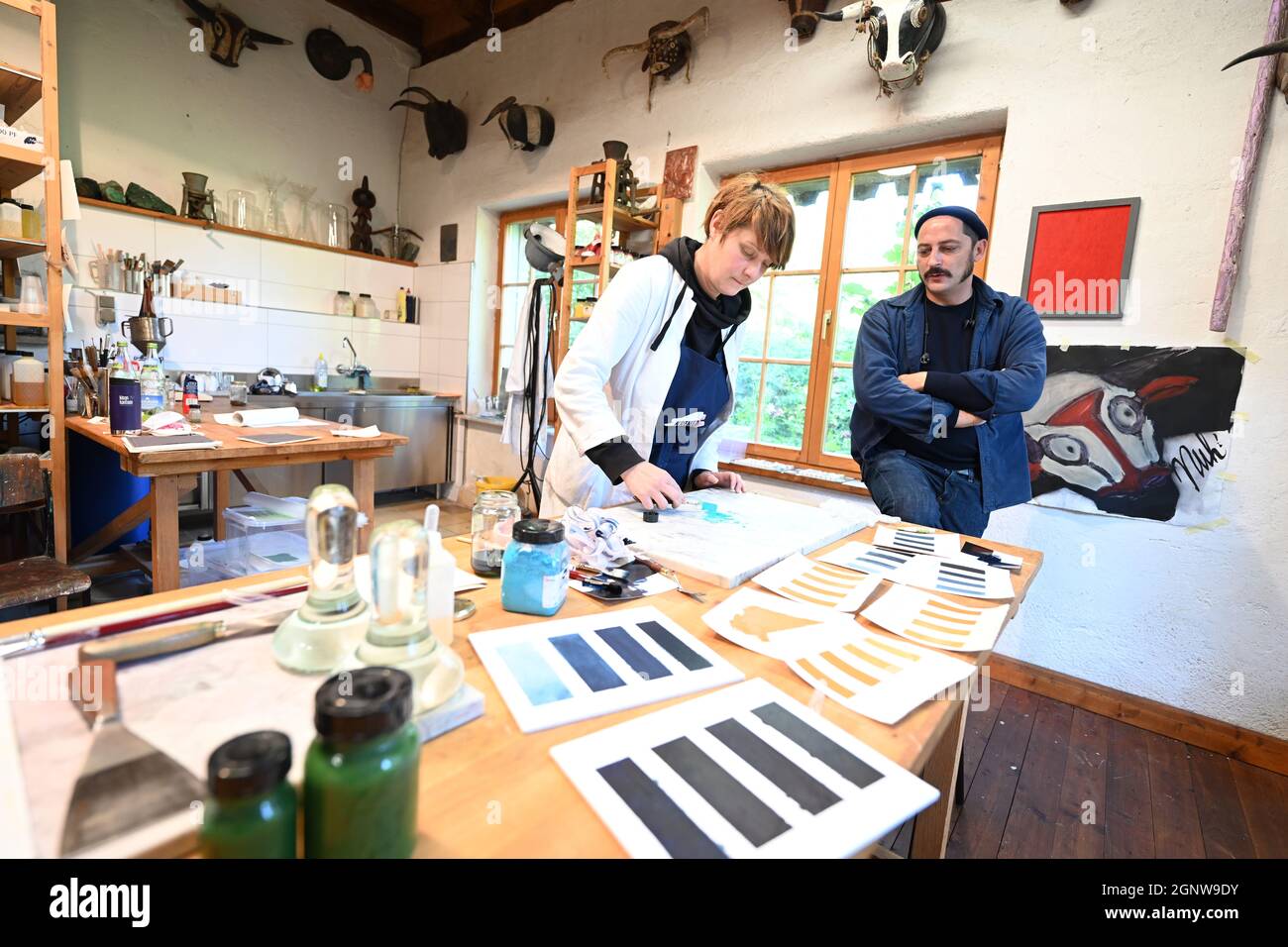 Aichstetten, Deutschland. September 2021. David Kremer, Geschäftsführer von Kremer Pigments, steht neben seiner Mitarbeiterin, der Künstlerin Birgits Saupe, die Farben mischt und testet. Mit Mühlsteinen, Öfen und Sieben macht eine alte Getreidemühle die Welt ein wenig bunter: Das Familienunternehmen im Allgäu ist eines der letzten weltweit, das historische Pigmente produziert. (An dpa-KORR 'Wer mahlt zuletzt: Mühle hält historische Farbproduktion am Leben') Quelle: Felix Kästle/dpa/Alamy Live News Stockfoto