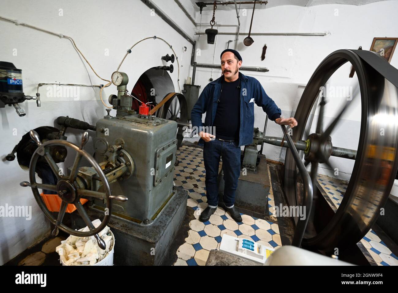 Aichstetten, Deutschland. September 2021. David Kremer, Geschäftsführer von Kremer Pigments, steht im Turbinenraum der ehemaligen Mehlmühle, die mit Wasser betrieben wird. Mit Mühlsteinen, Öfen und Sieben macht eine alte Mehlmühle die Welt ein wenig bunter: Das Familienunternehmen im Allgäu ist eines der letzten weltweit, das historische Pigmente produziert. (An dpa-KORR 'Wer mahlt zuletzt: Mühle hält historische Farbproduktion am Leben') Quelle: Felix Kästle/dpa/Alamy Live News Stockfoto