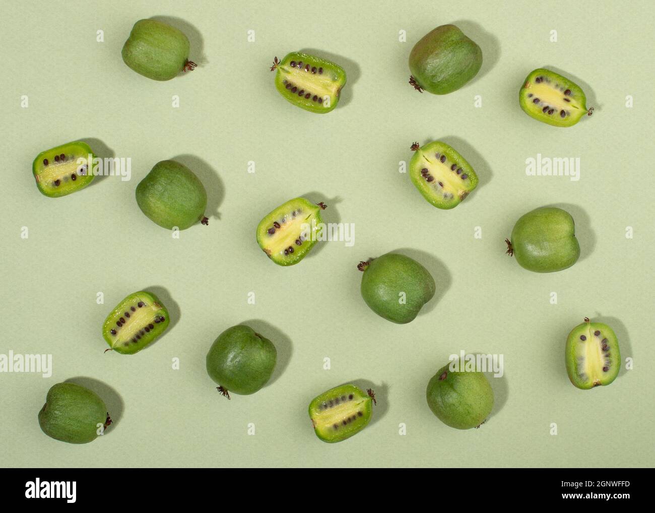 Frucht der Actinidia arguta, Kiwi-Beerenfrüchte auf grünem Hintergrund. Stockfoto