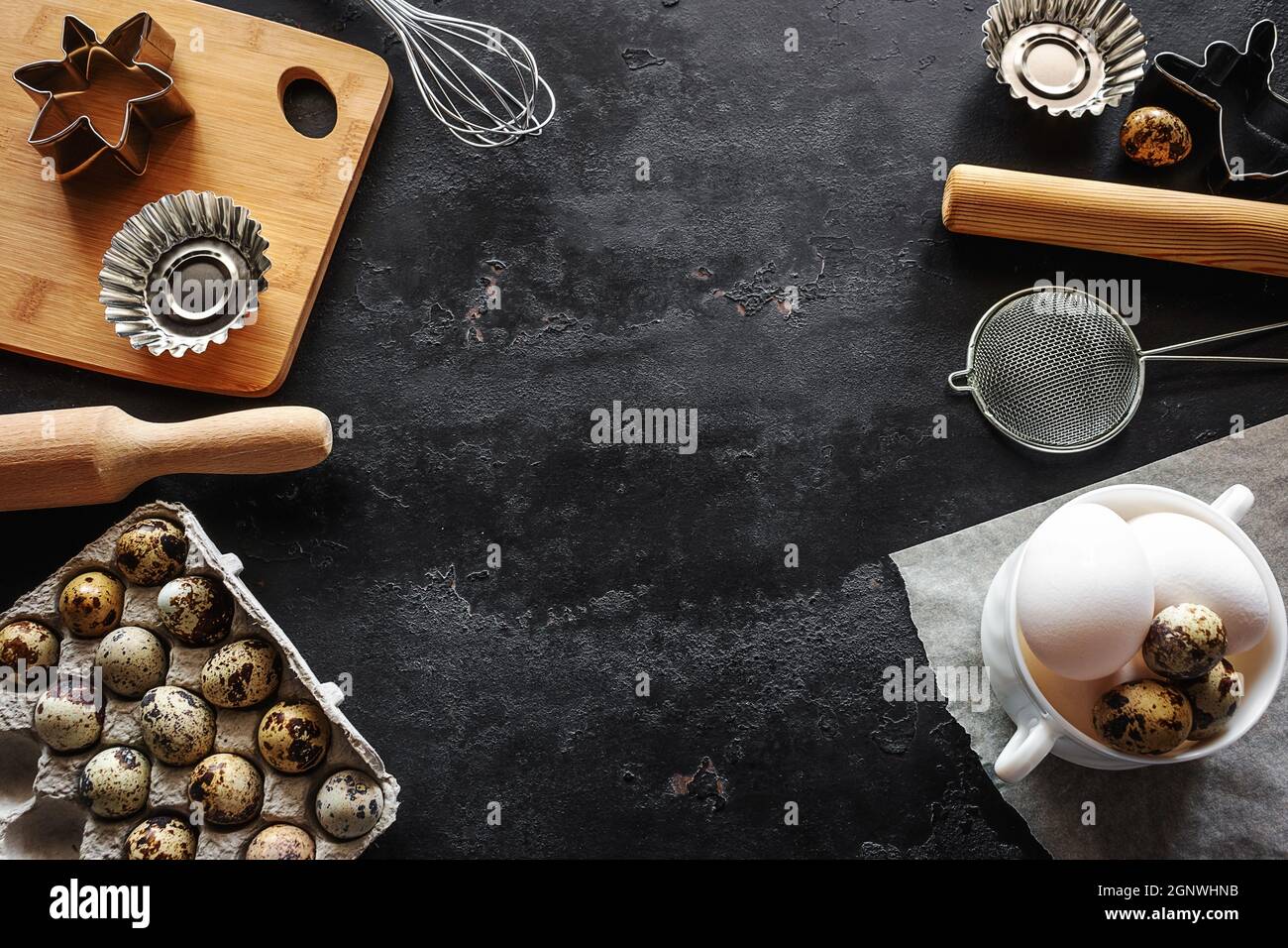 Lebensmittel und Utensilien zum Backen auf schwarzem Hintergrund mit Platz für Text Stockfoto