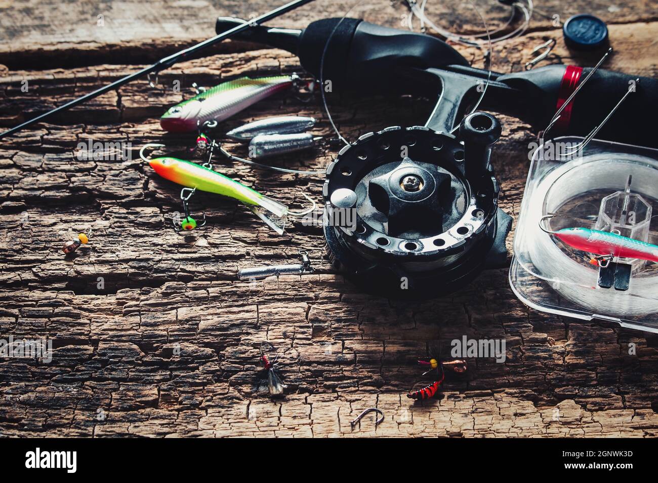 Angelrute und Köder zum Angeln auf Holzhintergrund Stockfoto