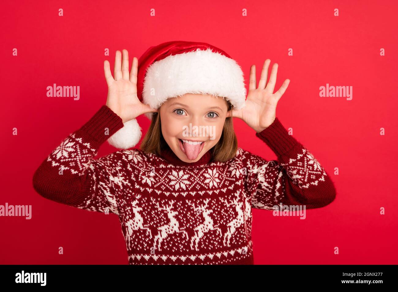 Foto von jungen kleinen Mädchen glücklich positive Lächeln Narren Grimasse Zunge-out spotten isoliert über rote Farbe Hintergrund Stockfoto