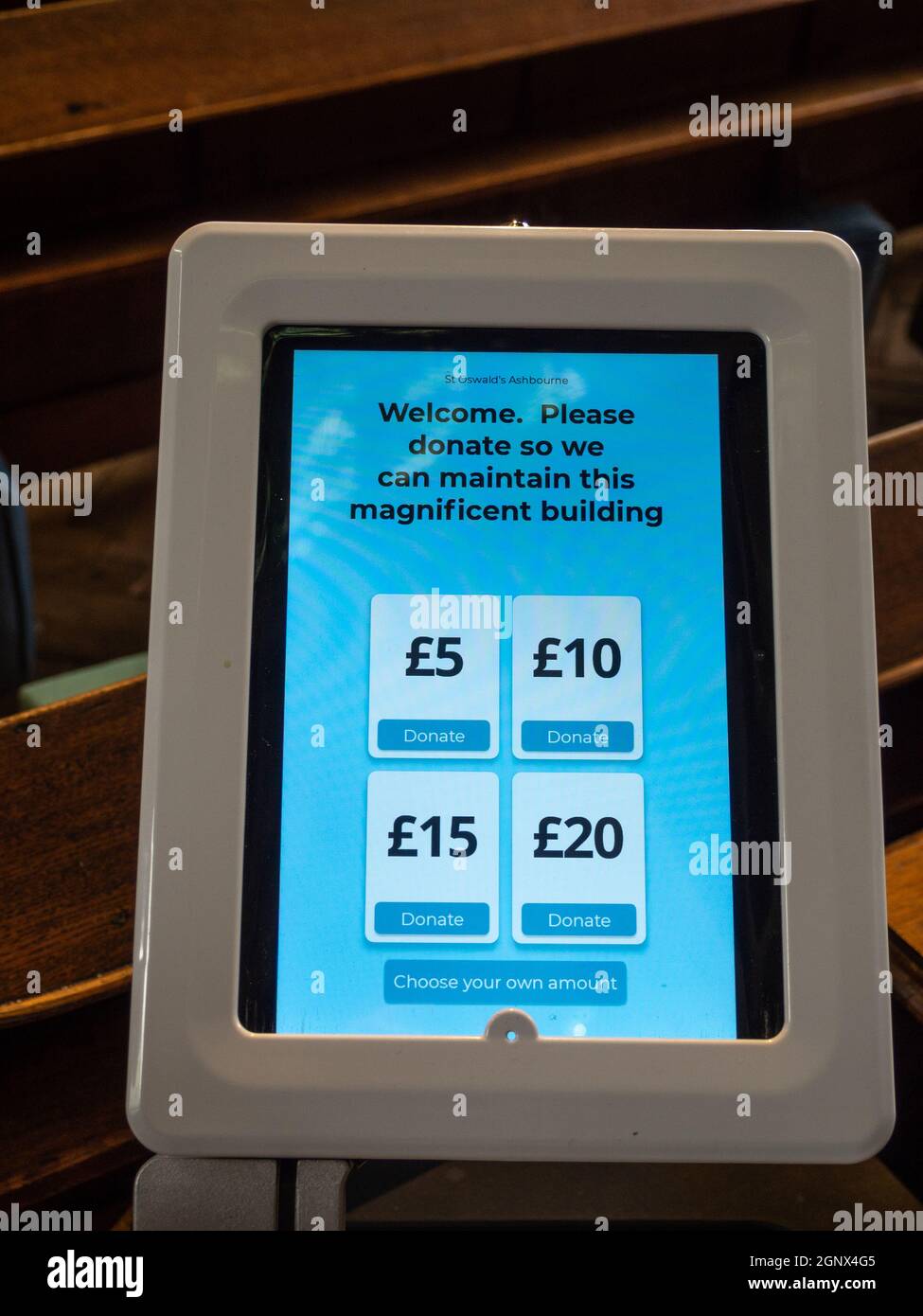 Maschine in einer britischen Kirche für kontaktlose Spenden für wohltätige Zwecke per Kredit- oder Debitkarte; der moderne Tag entspricht dem Sammelschild. Stockfoto