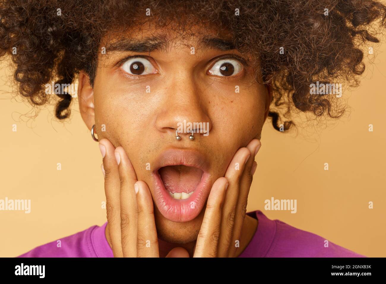 Mann mit lockigen Haaren ist über etwas erstaunt Stockfoto