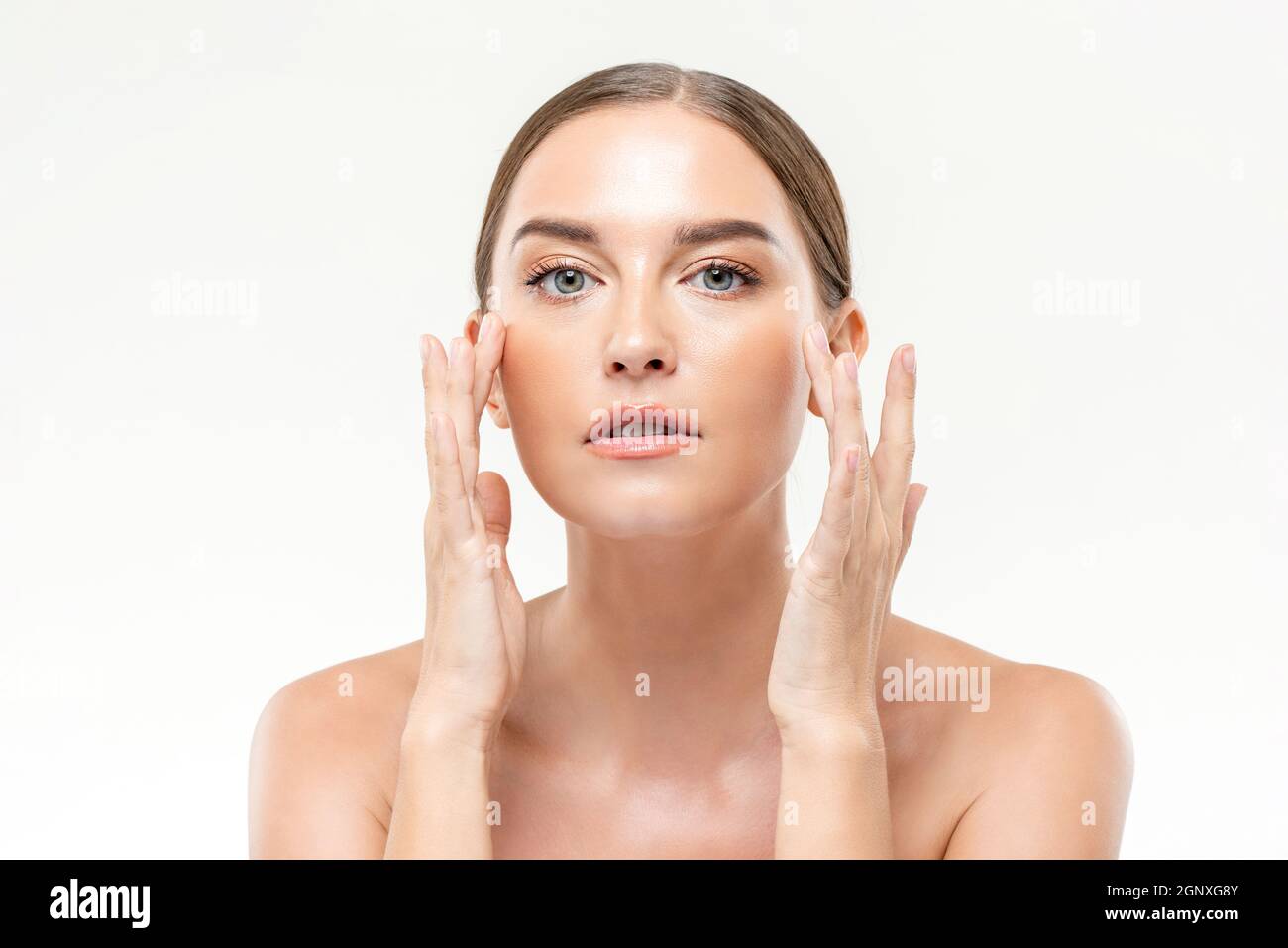 Beauty-Aufnahme von klar leuchtenden Haut Frau berührt ihr Gesicht auf weißen isolierten Studio Hintergrund für Hautpflege Konzepte Stockfoto
