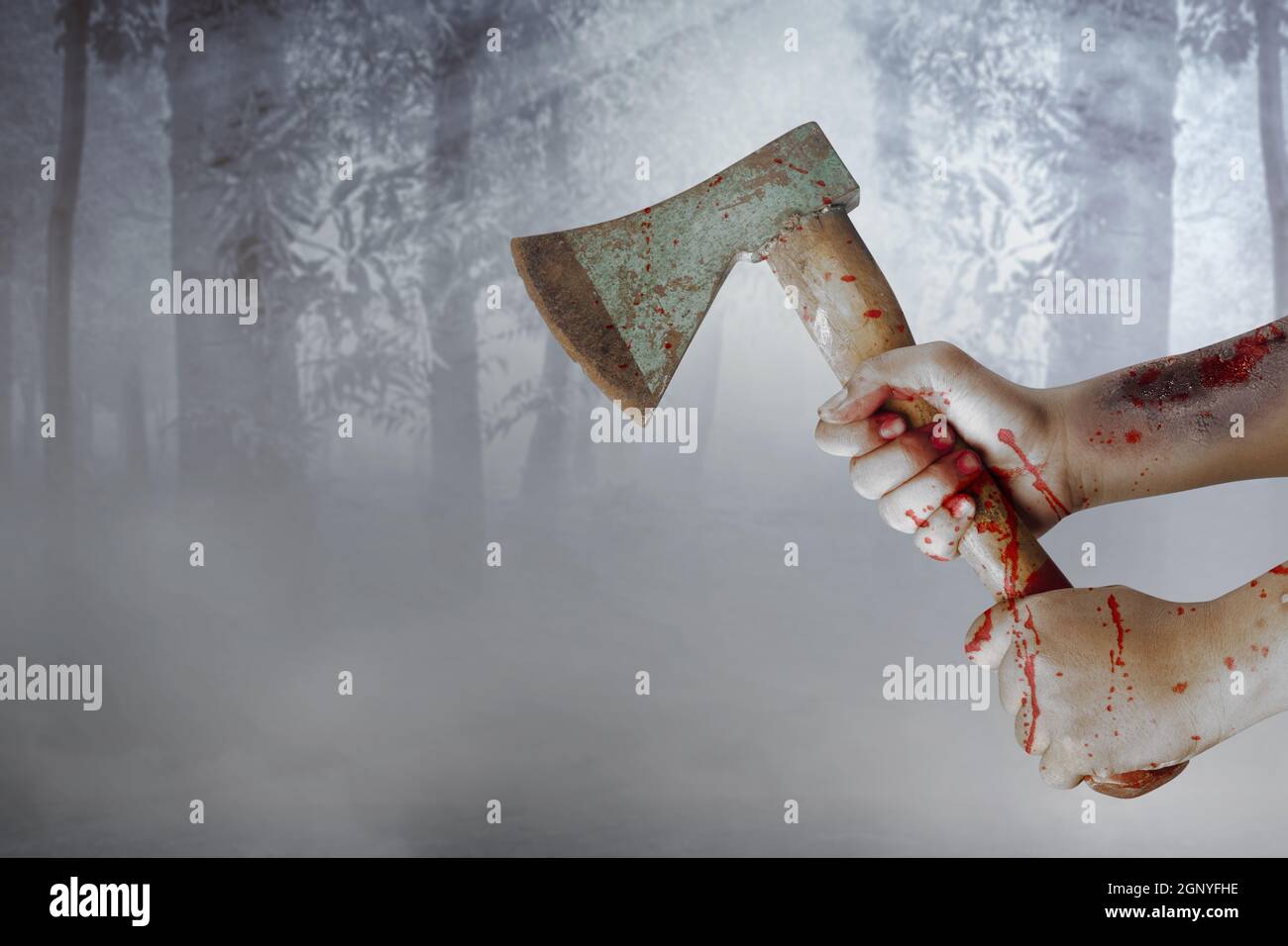 Zombie Hände mit Wunde halten Axt mit nebligen Hintergrund Stockfoto