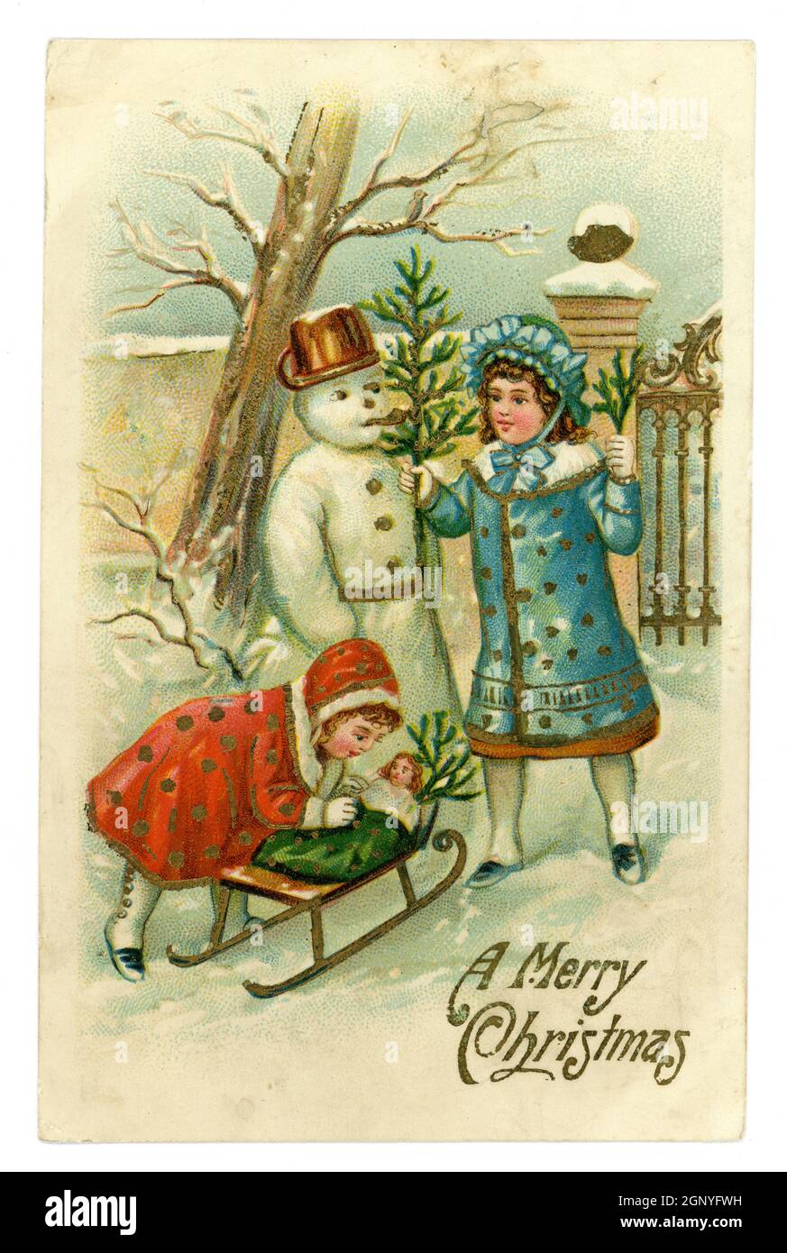 Original geprägte Weihnachtskarte aus britischer Edwardianenzeit, junge Mädchen mit einer Puppe auf einem Schlitten in ihrem Garten, um einen Schneemann zu bauen, herausgegeben von A.S.B. gedruckt in Deutschland, um 1910 Stockfoto