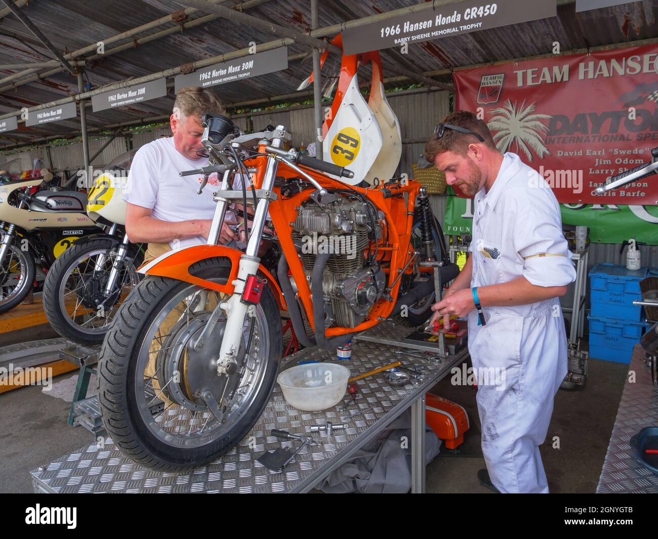 Motorradmechaniker, die beim Goodwood Revival 2021 an einem Oldtimer-Rennrad arbeiten Stockfoto