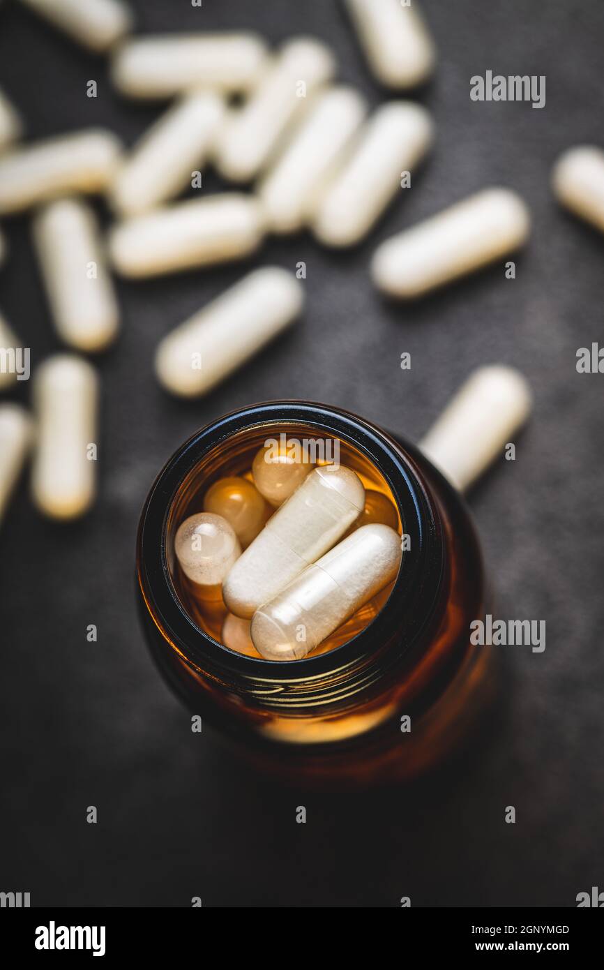 Weiße medizinische Pillen in Behälter. Pharmazeutische Medizin Pillen, Tabletten und Kapseln in Glas. Stockfoto