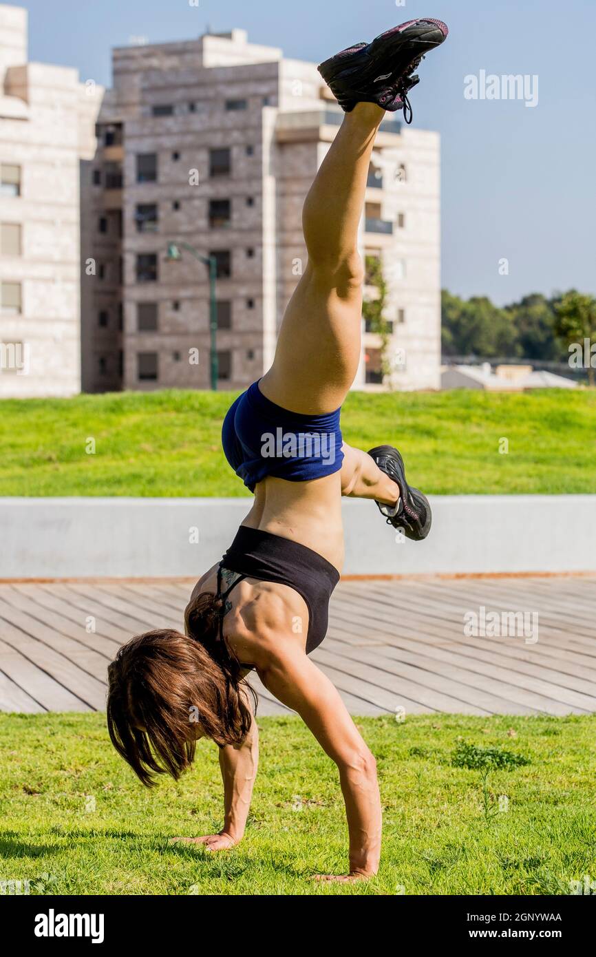 Junge Bodybuilderin übt im Freien in einem Park Stockfoto