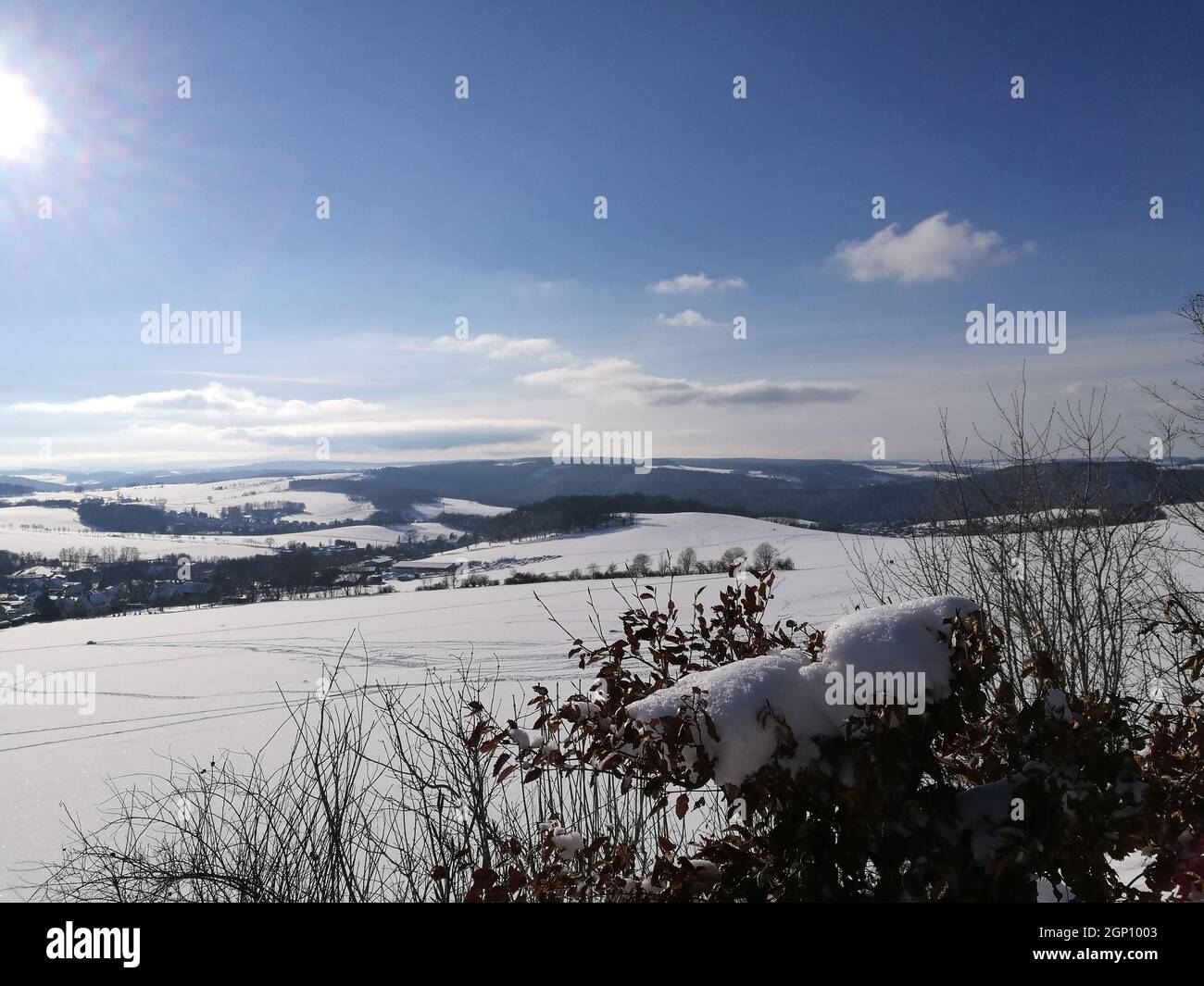 Skispuren in einer Winterlandschaft; hügelige Landschaft im Erzgebirge in Sachsen, Wintersonne am blauen Himmel, Ski traces in a Winter Landscape; hallo Stockfoto