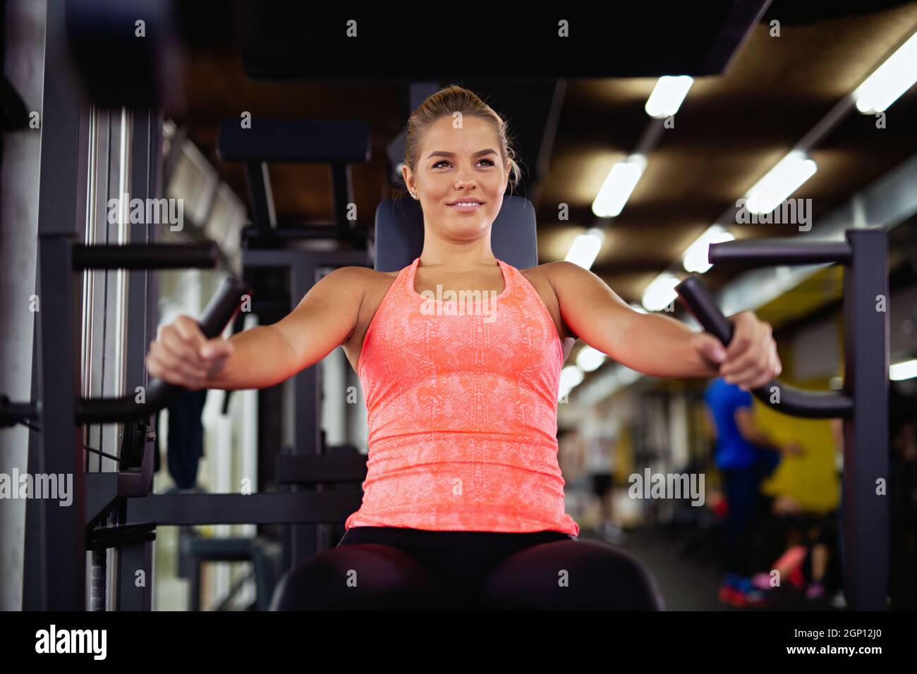 Junge Fitness-Frau trainieren mit einem Fitnessgerät im Fitnessstudio. Gesundheitssport fit people Konzept Stockfoto