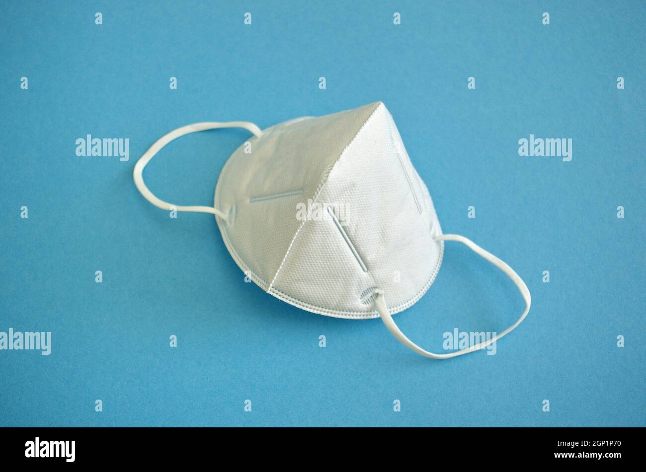 KN95 oder N95 FFP2 Maske für Schutz PM 2,5 und Coronavirus (COVID-19). Anti Verschmutzung Maske.Luft Gesichtsmaske, FFP2 N95 Maske auf blauem Hintergrund. Stockfoto