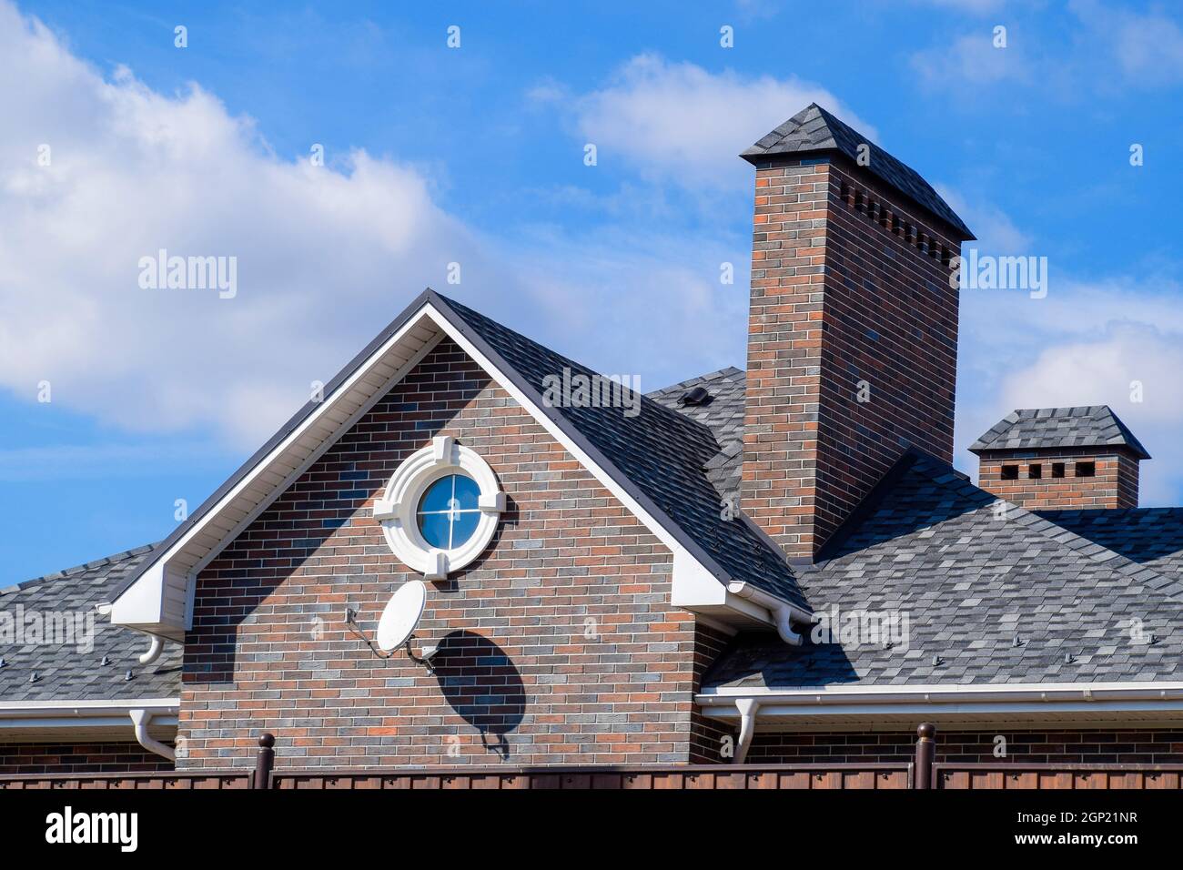 Asphalt Kies. Dekorative bitumen Schindeln auf dem Dach eines Brick House Stockfoto