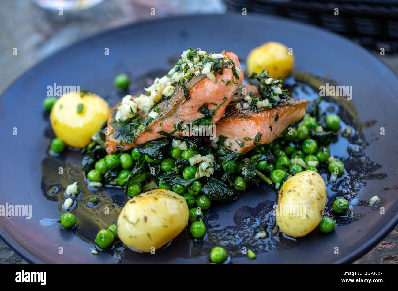 Lachsfilet mit grünen Erbsen und Spinat Stockfoto