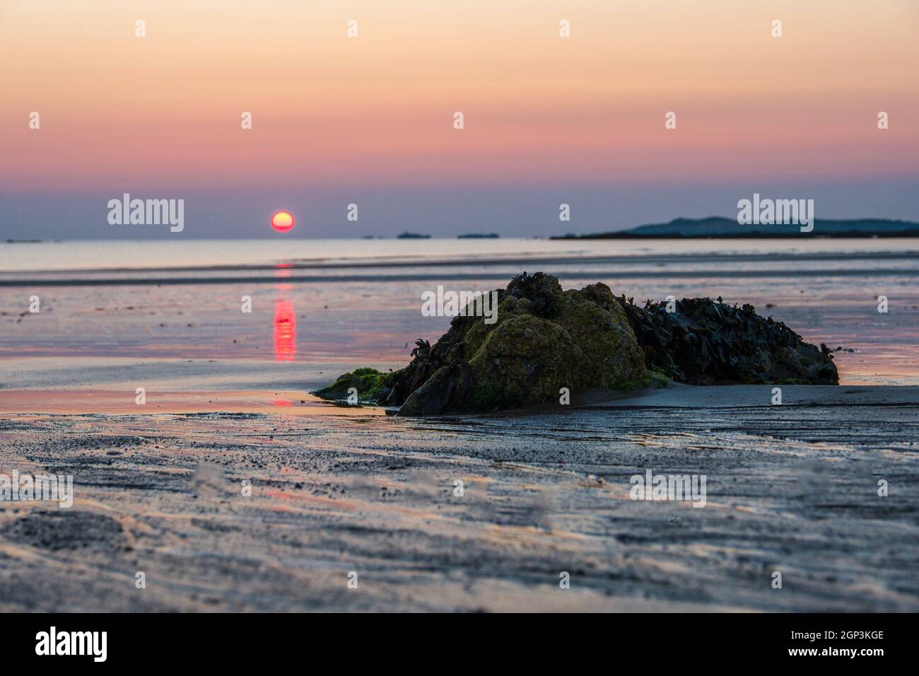 Sonnenuntergang am Strand, Anglesey Westküste in der Nähe von Rhoseigr, Wales, Großbritannien Stockfoto