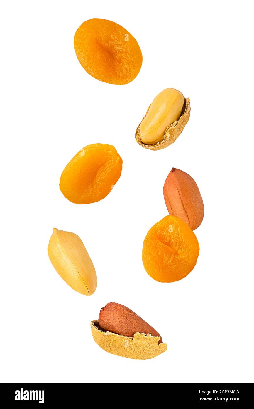 Isolierte Früchte und Nüsse. Sieben fliegende Erdnüsse mit Schale und getrockneten Aprikosen isolieren auf Weiß mit Clipping Path als Paket-Design-Element. Volle Abt Stockfoto
