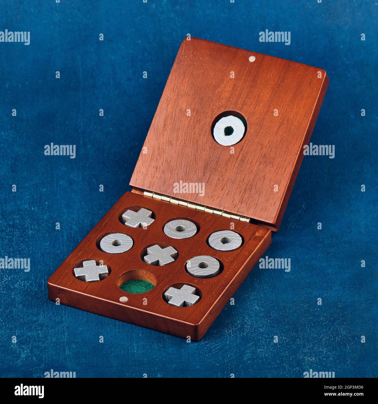 Tischspiel Tic Tac Toe in einer Holzkiste auf blauem Hintergrund, geringe Schärfentiefe Stockfoto