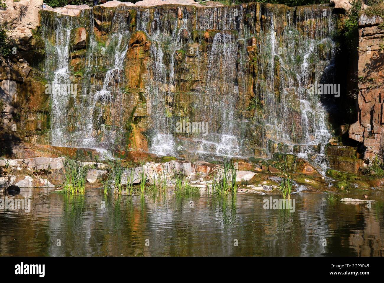 Im Frühling fließt ein malerischer Wasserfall zwischen großen Steinen im Landschaftspark Sofiyivka, Uman, Ukraine. Schöner ukrainischer Wasserfall, Berge Stockfoto