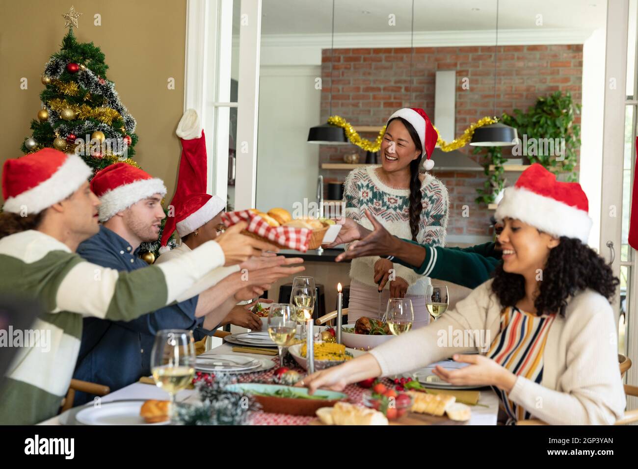 Eine Gruppe glücklicher, vielfältiger weiblicher und männlicher Freunde, die zu Hause Weihnachten feiern Stockfoto