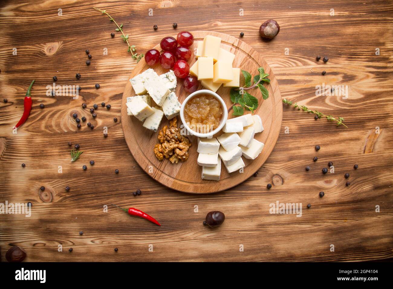 Vorspeise mit verschiedenen Käsesorten für Wein. Käseplatte sortiert: dor blau, Cheddar, Ziegenkäse, Feta-Käse. Nüsse und Honig für Käse. Konzept - Männer Stockfoto