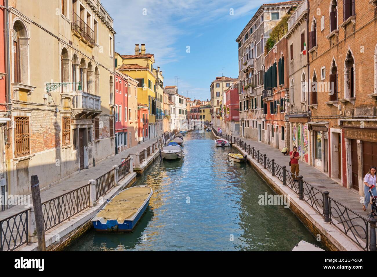 Blick über einen schmalen Kanal und geparkte Boote in Venedig, Italien Stockfoto