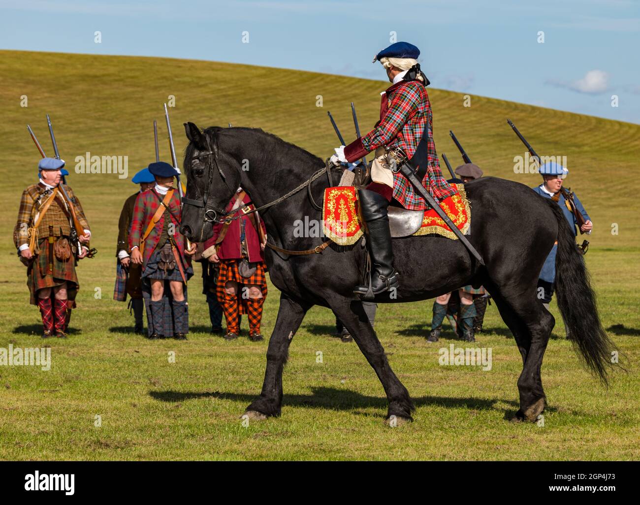 Bonnie Prince Charlie reitet auf einem Pferd und seine jakobitischen Truppen in einem historischen Kostüm in Nachstellung der Schlacht von Prestonpans , East Lothian, Schottland, Großbritannien Stockfoto