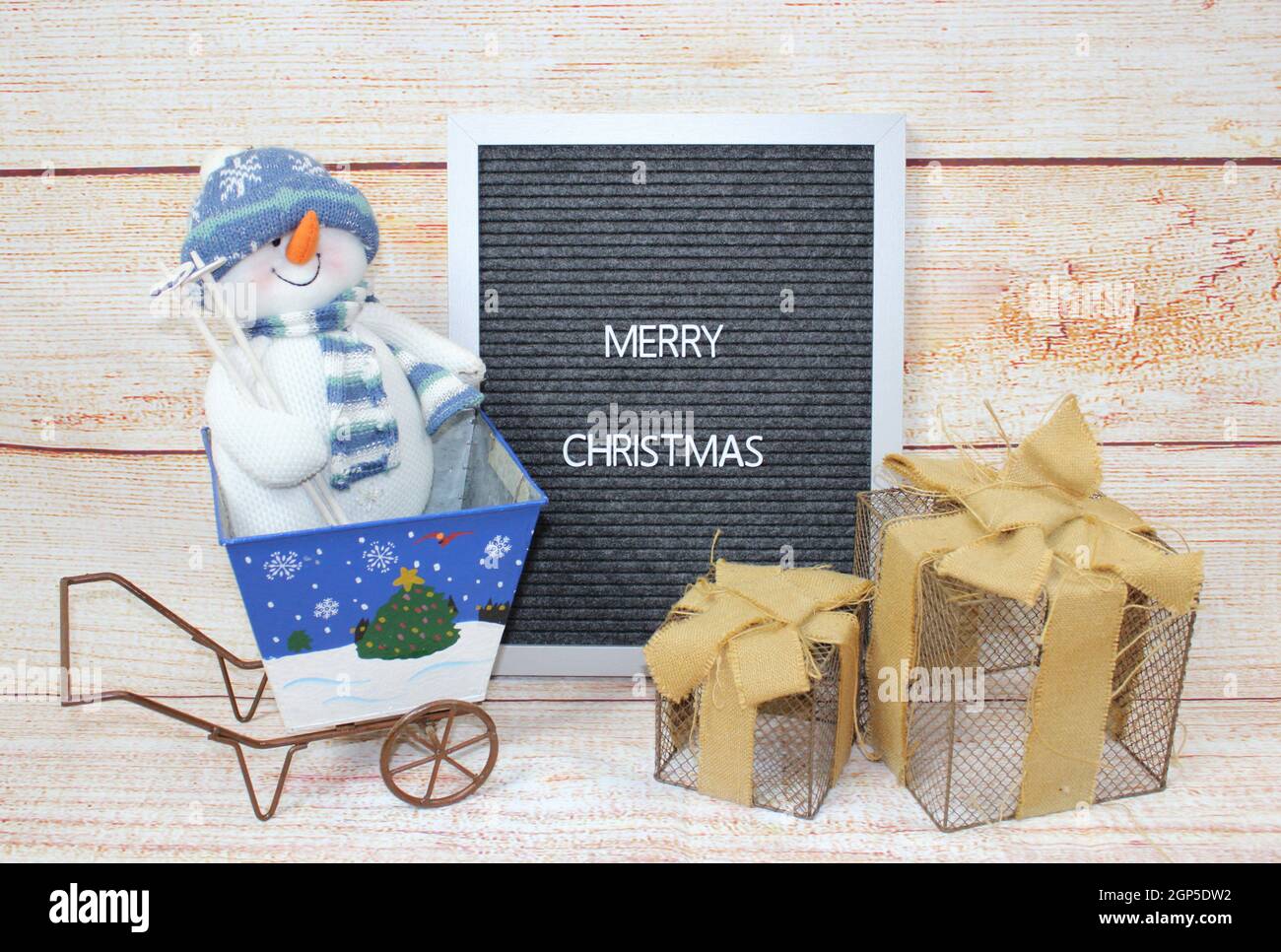 Fröhliches Weihnachtsschild mit Schneemann und Geschenken. Stockfoto