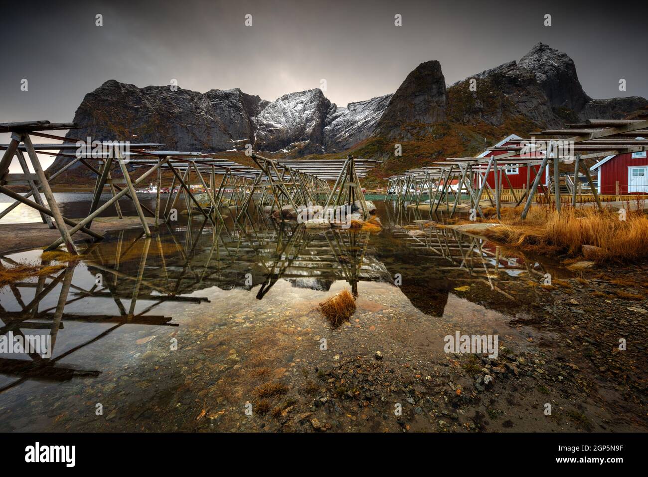 Landschaft eines Fischerdorfes in Norwegen. Konstruktion für das Trocknen von Fischen am Ufer. Traditionelle Arbeit in norwegischen Landschaften. Stockfoto