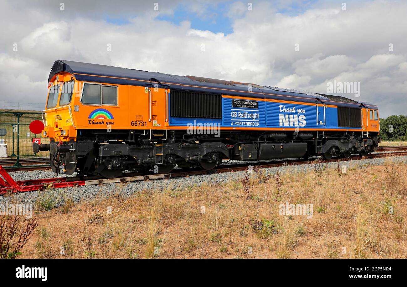 GBRF 66731 in NHS-Lackierung wartet am 10.9.21 am Linienterminal East Midlands Gateway. Stockfoto