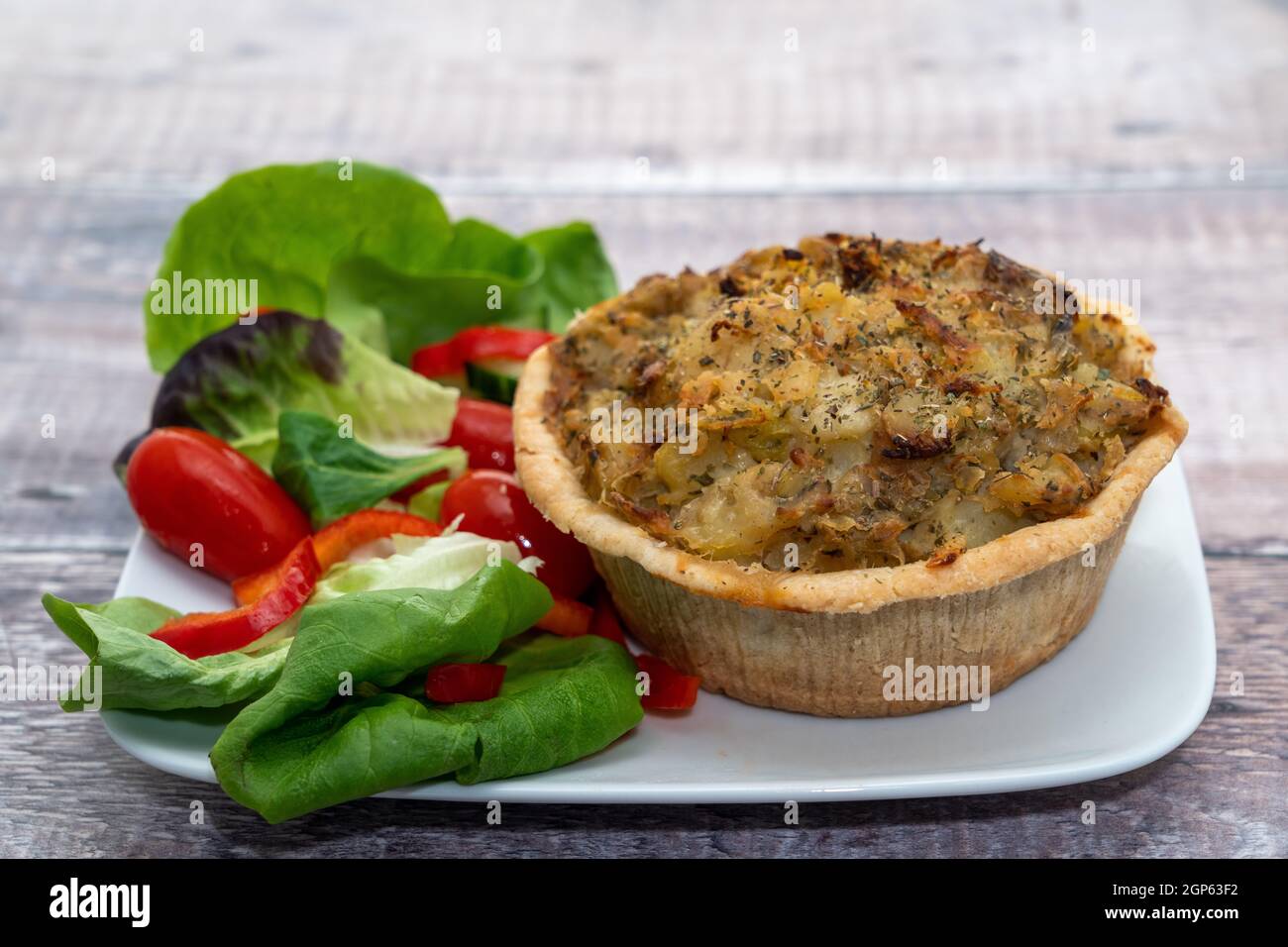 Homity Pie – ist ein Pappkuchen mit Kartoffelbrei, Zwiebeln und Käse, der mit Salatartikeln serviert wird Stockfoto