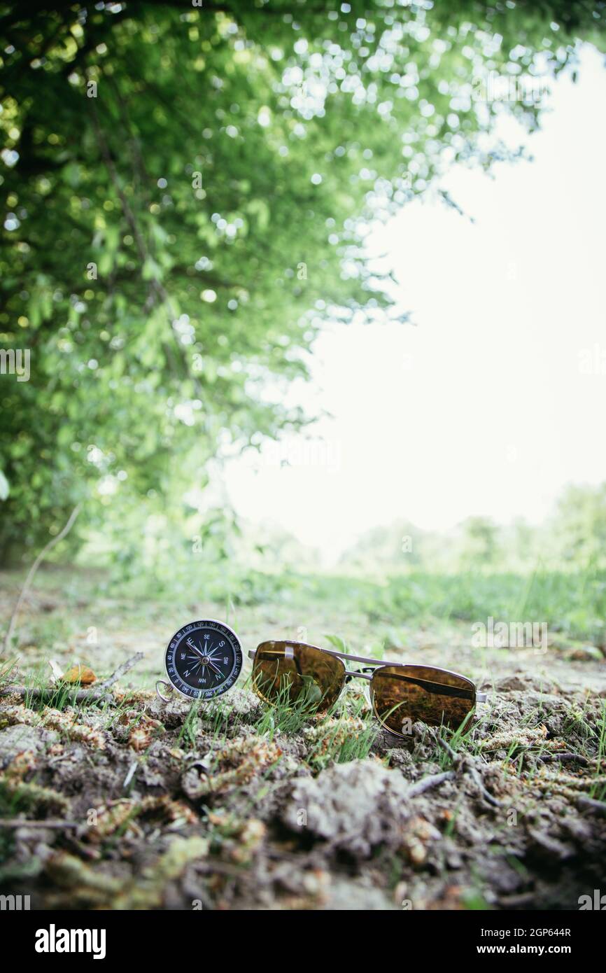 Vintage Kompass und Sonnenbrille auf dem Boden liegt. Abenteuer und Entdeckung Konzept. Stockfoto