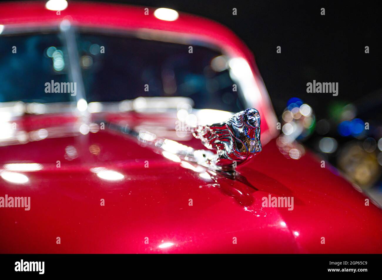 Metallfigur auf der roten Motorhaube eines Oldtimers, Nahaufnahme, selektiver Fokus, weicher Fokus Stockfoto