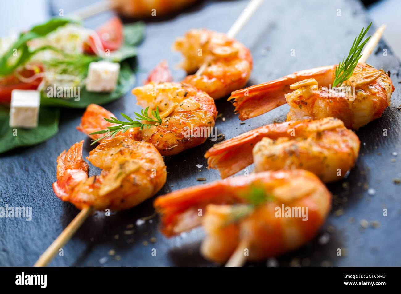 Makro-Nahaufnahme von scharf würzigen gegrillten Queen-Garnelen-Brochettes. Stockfoto